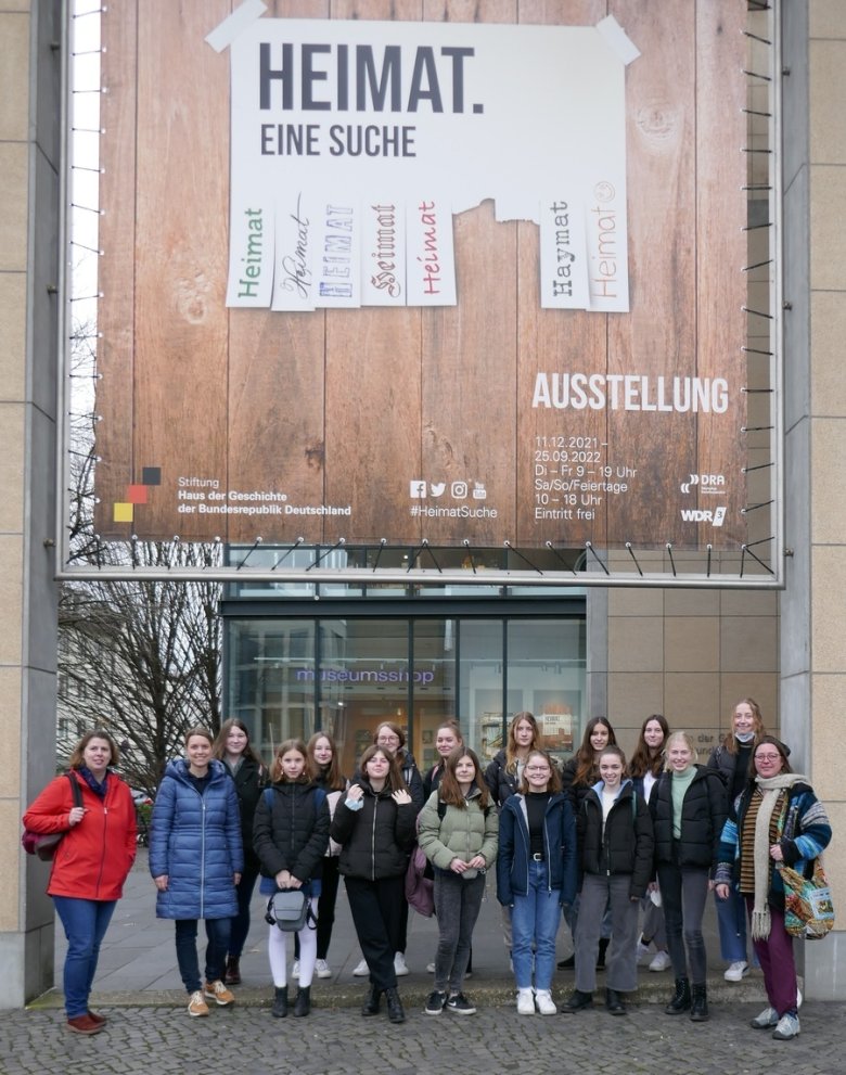 Exkursionsgruppe unter dem Ausstellungsbanner Heimat vor dem Bonner Haus der Geschichte