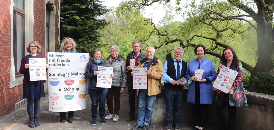 Sie sehen (mit Plakaten): Elke Wolf (OST), Stadtarchivarin Karin Schlesiger, Agnes Renkert (Leineweber), Betty Schürmann (Puppenmuseum), Bruno Kippelt, Manfred Schründer (Heimatverein), Dr. Guido Dahl (Kulturforum), Bürgermeisterin Christa Lenderich und Tanja Withut (Töpfereimuseum) 