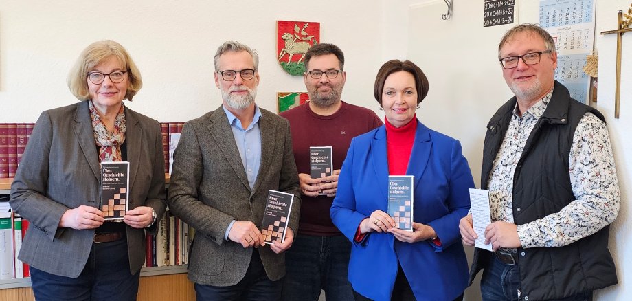 Sie sehen eine Personengruppe ( v.l.: Stadtarchivarin Karin Schlesiger, Schulleiter Olaf Reitenbach, Geschichtslehrer Udo Schwertheim, Bürgermeisterin Christa Lenderich und Kulturamtsleiter Christian Engelmann).