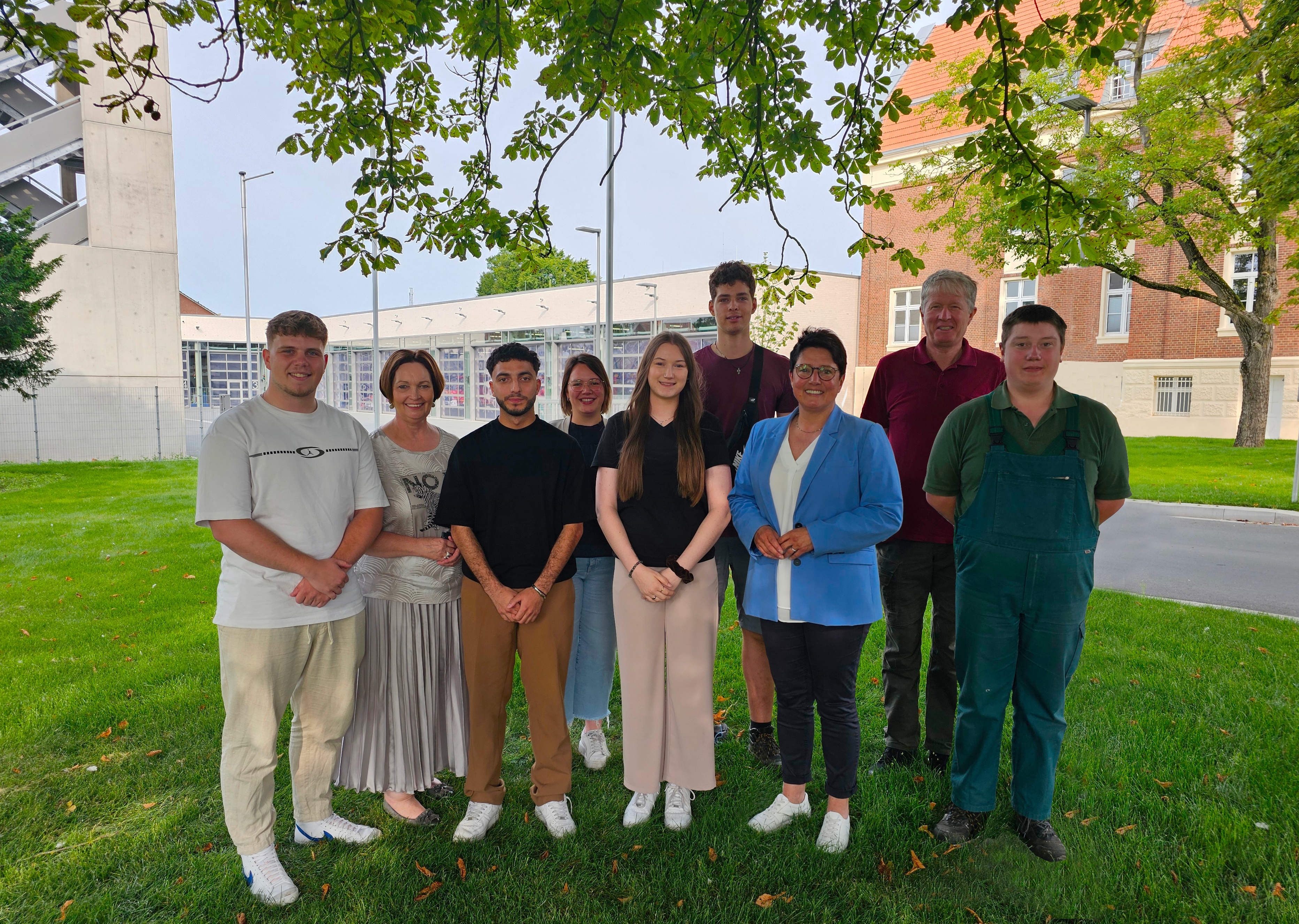 Sie sehen: eine Gruppe von Menschen. (V.l.: Tom Dierker, Bürgermeisterin Christa Lenderich, Ali Beydoun, Ausbildungsleiterin Teresa Stauvermann, Katharina Helling, Max Reinker, Erste Beigeordnete Birgit Stening, Gärtnermeister Franz Laurenz und Chris Hannekotte.