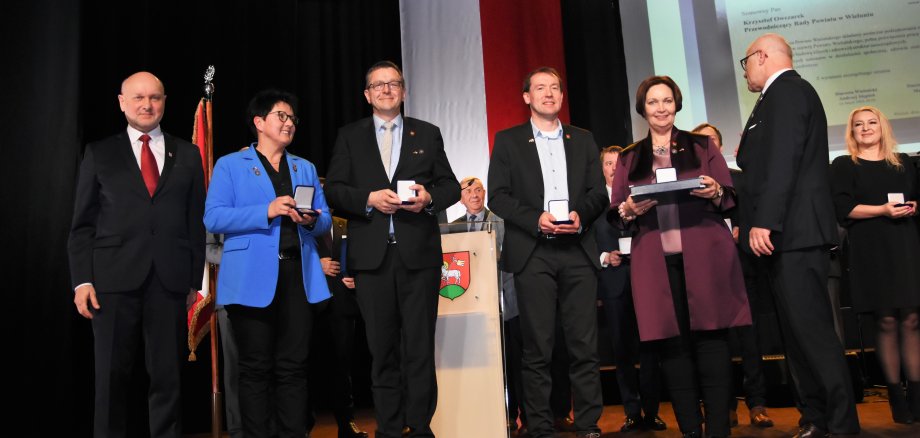 Sie sehen eine Personengruppe:  (v.l.): Wieluns Kreistagsvorsitzender Krzysztof Owczarek, Birgit Stening, Holger Brüggemann, Robert Tausewald, Bürgermeisterin Christa Lenderich und Wieluns Landrat Marek Kieler