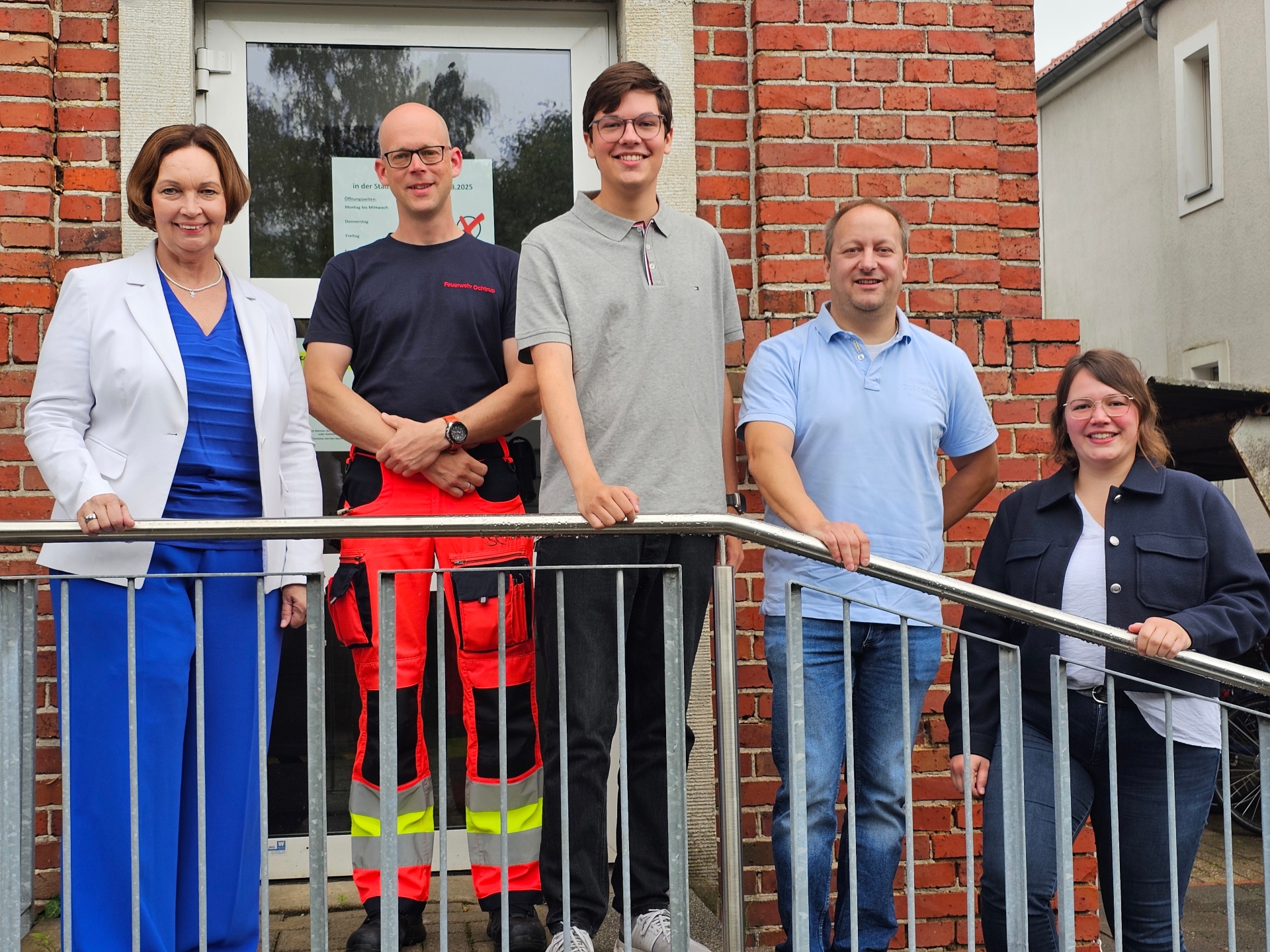Sie sehen: eine Menschengruppe auf der Treppe vor dem Rathauseingang