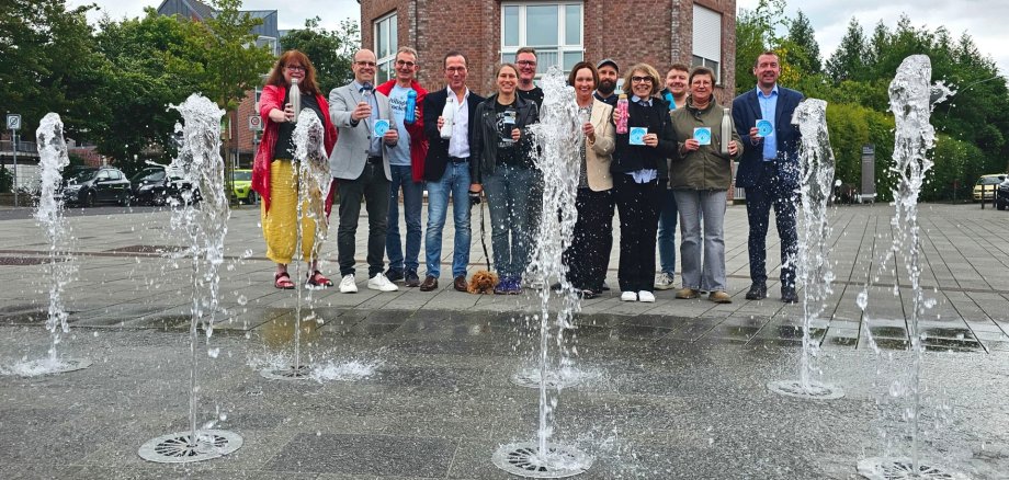 Sie sehen: eine Gruppe von Menschen hinter Wasserfontänen
