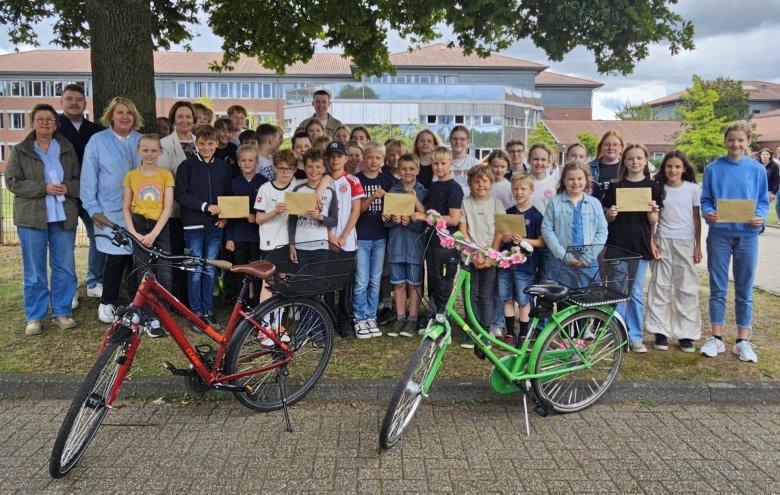 Sie sehen: Eine Gruppe Kinder gemeinsam mit den erwachsenen Organisatoren des Schulradelns, davor Fahrräder.