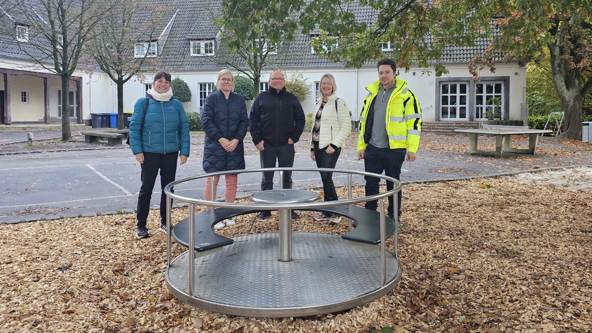 Sie sehen: Eine Personengruppe hinter einem Sitzkarussell