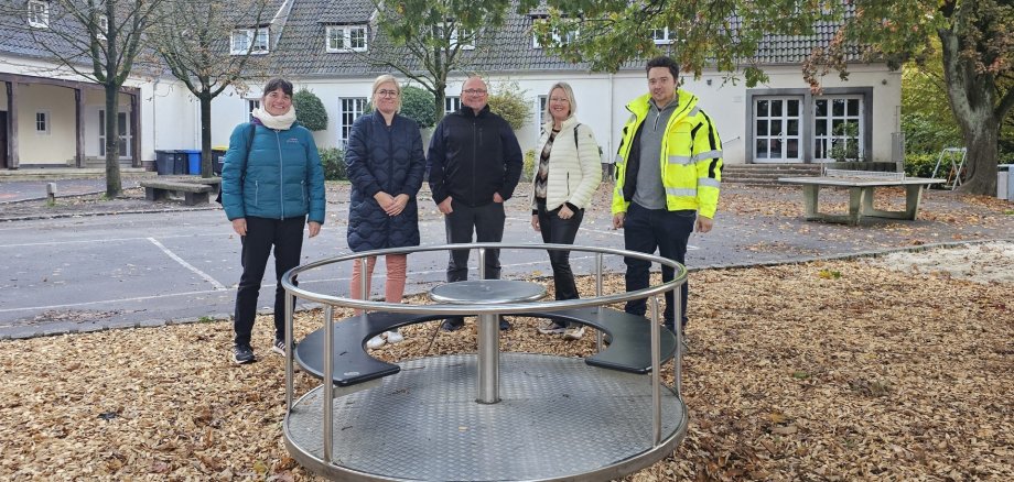 Sie sehen: Eine Personengruppe hinter einem Sitzkarussell