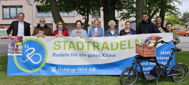 Sie sehen: Eine Personengruppe vor dem großen Banner von STADTRADELN