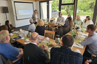 Sie sehen: Personen in einem Konferenzraum. Bürgermeisterin Christa Lenderich begrüßt die Tagungsteilnehmer in der Villa Winkel.