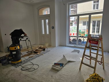 Sie sehen: Einen Arbeitsraum mit Leiter und einem Mann an der Kreissäge