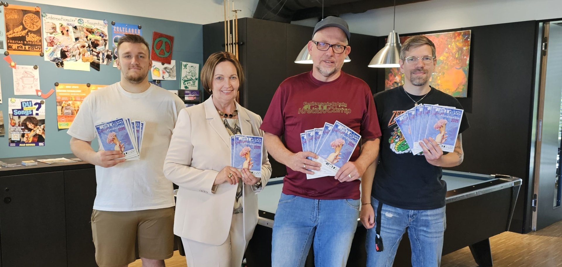 Sie sehen: eine Personengruppe mit Programmheften in den Händen (Flavio Tiltmann (Café Freiraum), Bürgermeisterin Christa Lenderich, Jörg Eßlage und Fabian Walke (Café Freiraum) freuen sich auf die Anmeldungen zum Ferienspaß in Ochtrup). 