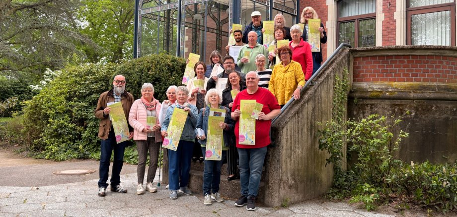 Sie sehen: eine Personengruppe auf einer Treppe vor der Terrasse der Villa Winkel im Stadtpark