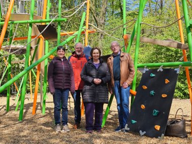 Sie sehen: eine Personengruppe vor Spielgeräten