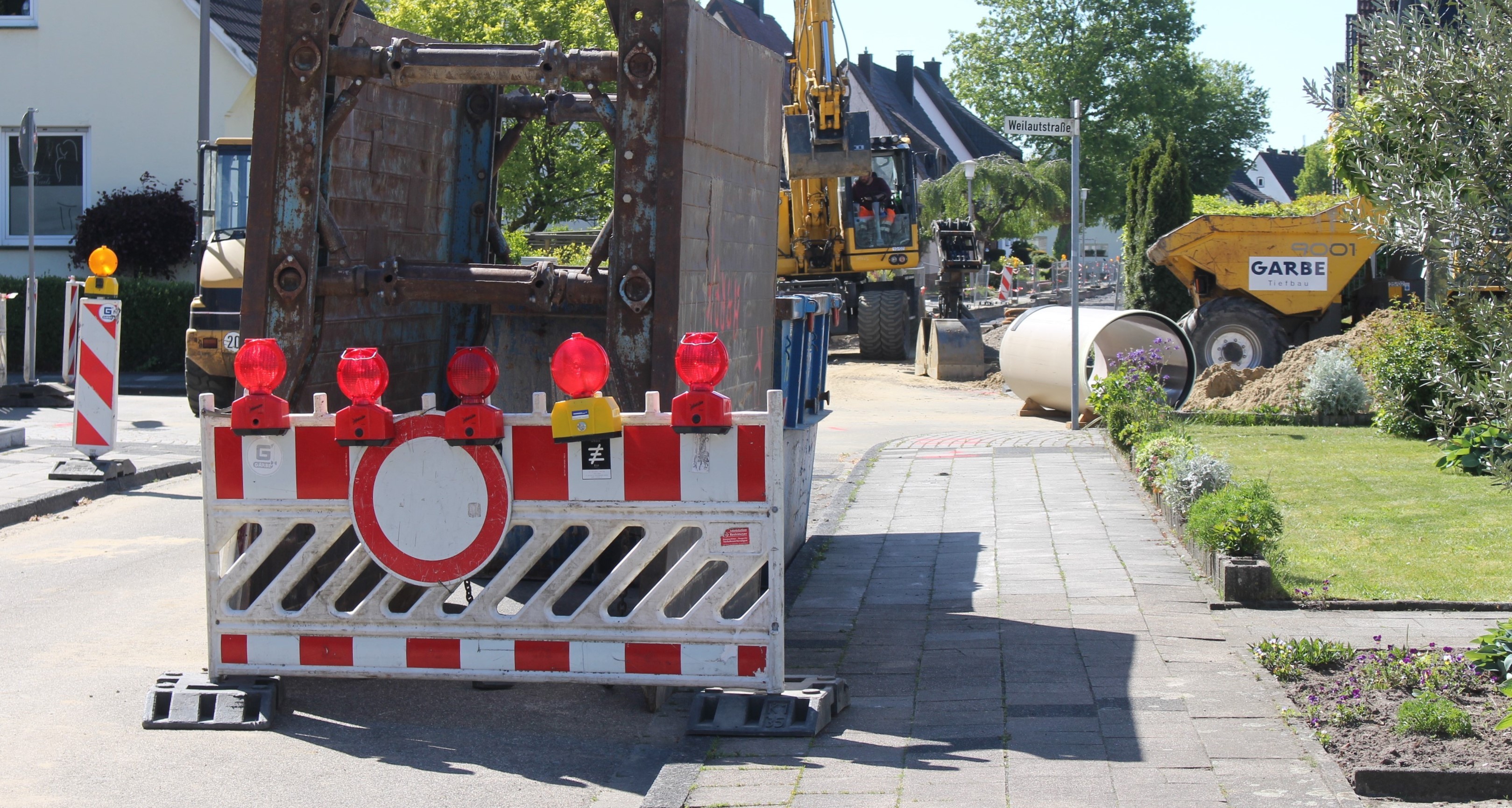 Baustelle mit Straßensperrungsschild im Vordergrund