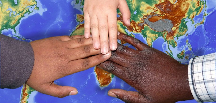 Kinderhände mit unterschiedlichen Hautfarben halten sich