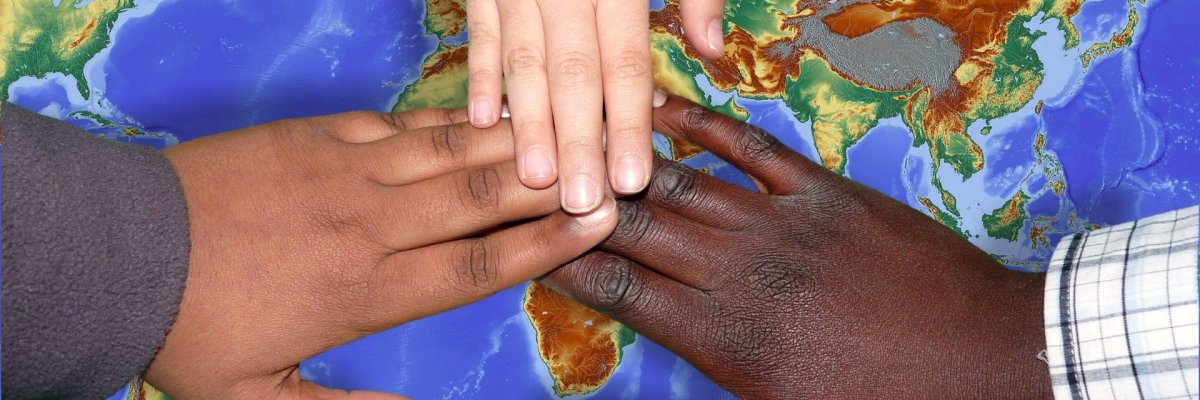 Kinderhände mit unterschiedlichen Hautfarben halten sich