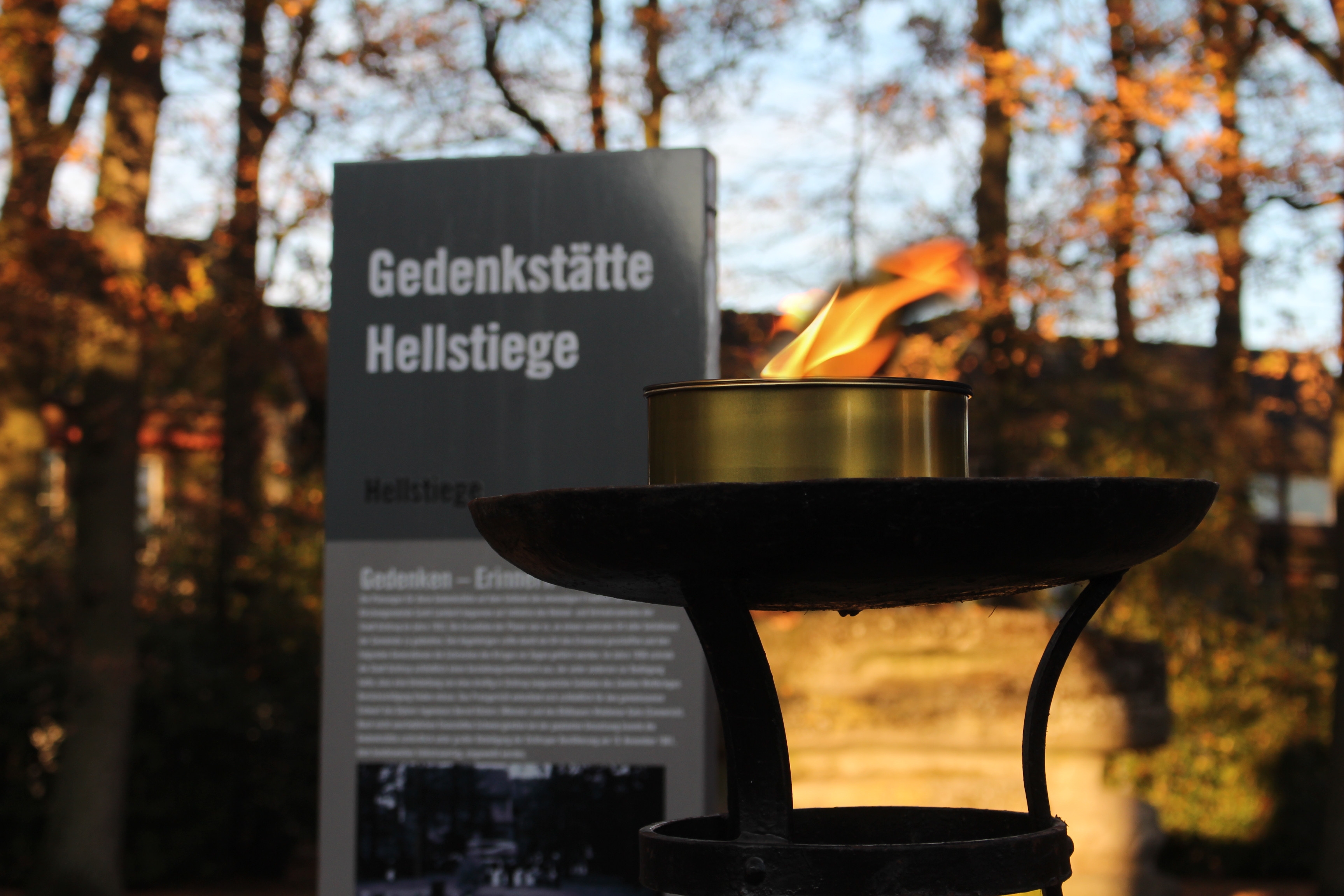 Infostele mit Fackel am Eingang der Gedenkstätte Hellstiege
