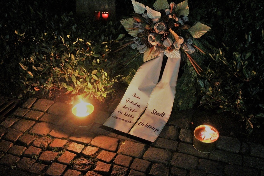 Am Gedenkort niedergelegter Kranz und Kerzen zum Reichspogromgedenken