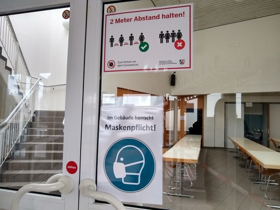 Tür zur Stadthalle mit Schildern zu Hygienemaßnahmen