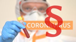 Medizinische Fachkraft im Labor mit Reagenzglas und Illustation Gesetzesparagraph