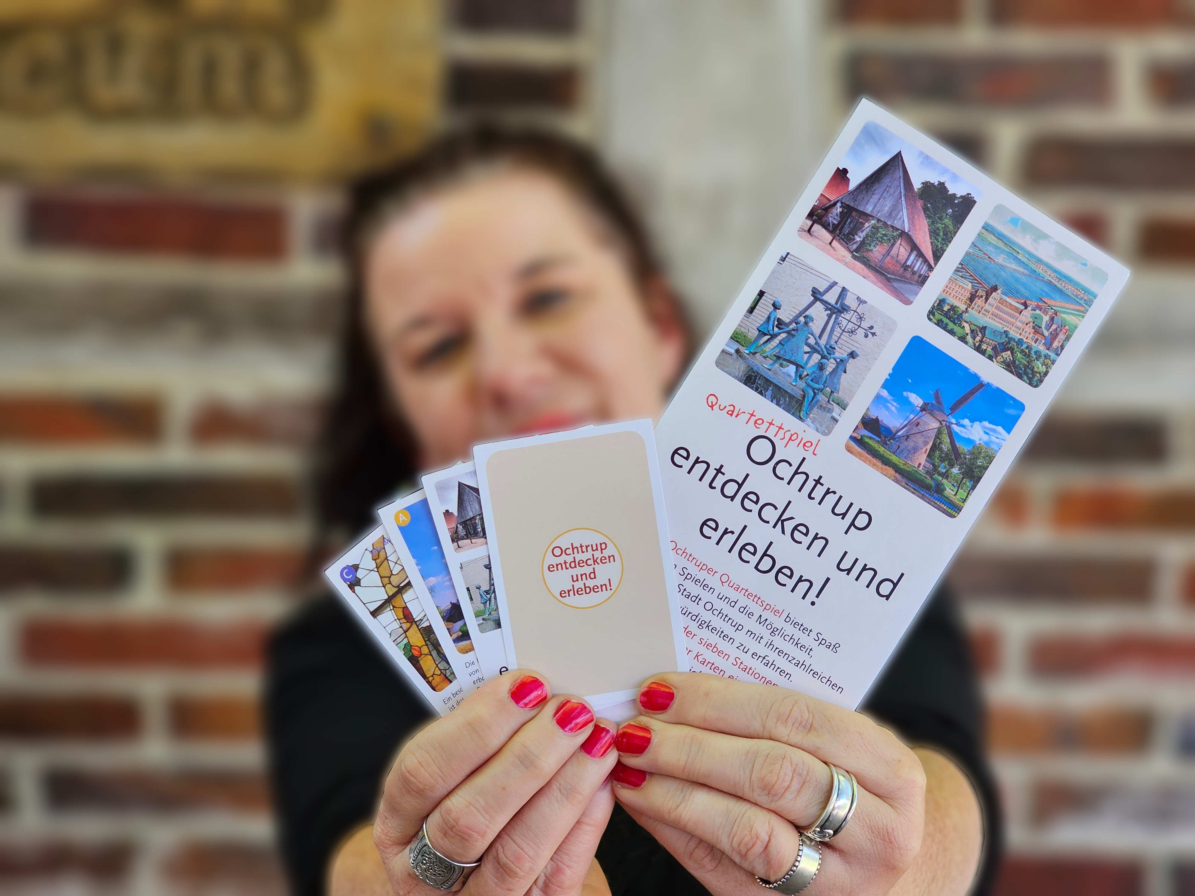 Sie sehen: eine Person, die ein aufgefächertes Kartenspiel in die Kamera hält