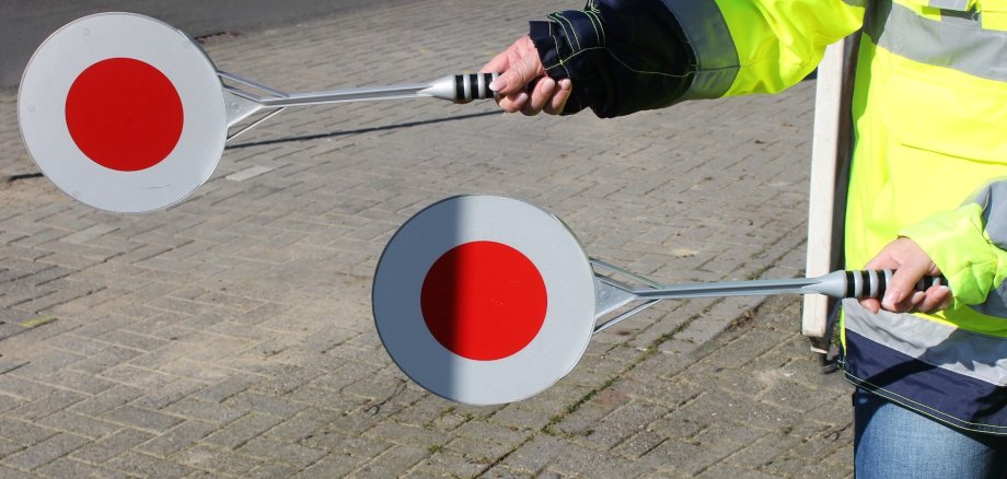 Sie sehen: die roten Kellen von zwei Schülerlotsen