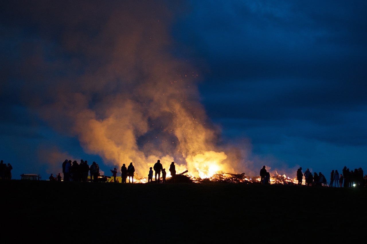 Sie sehen: die Silhouetten von Menschen vor einem Osterfeuer