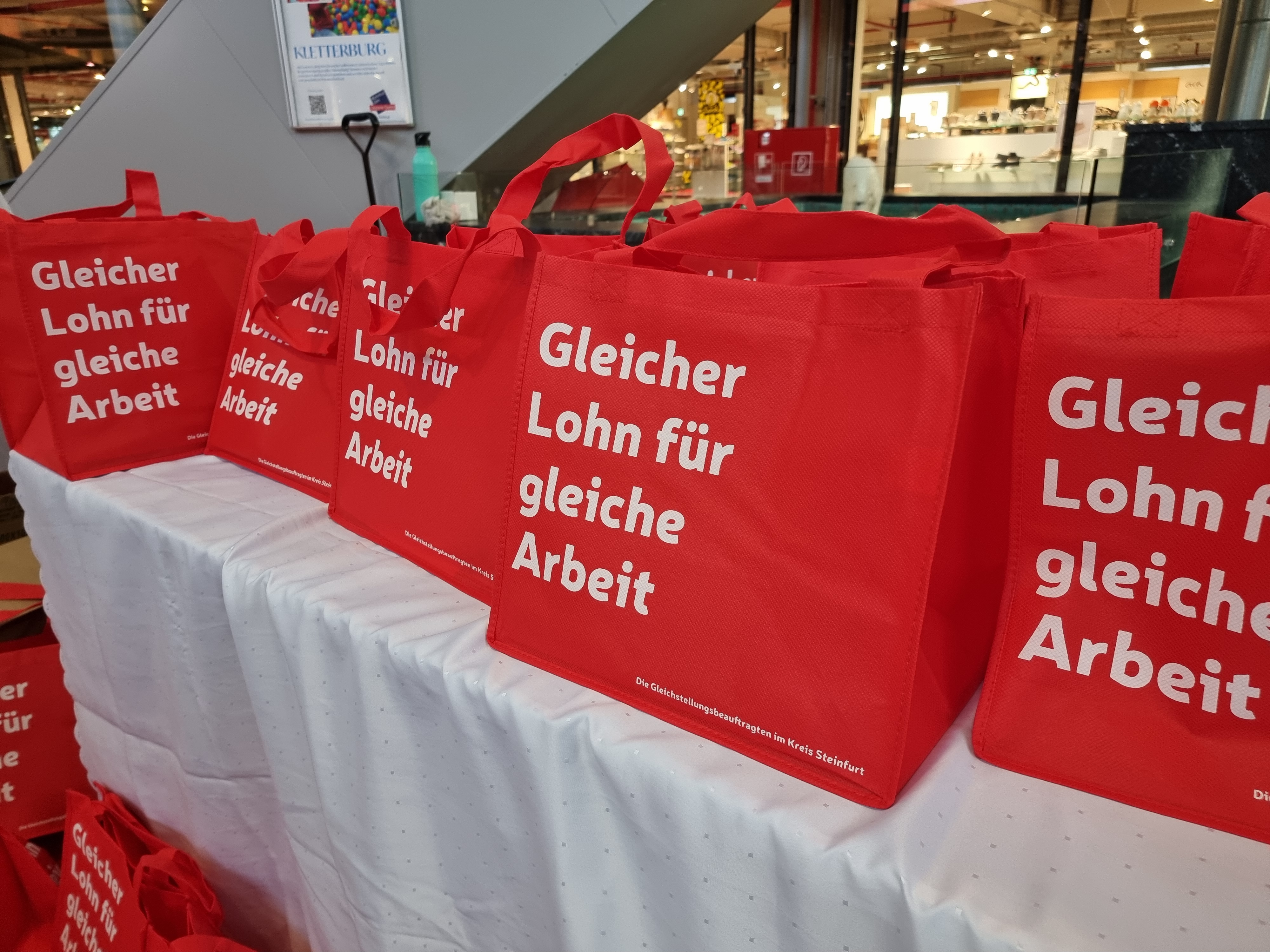 Sie sehen: rote Taschen den Equal Pay Day mit der Aufschrift: "Gleicher Lohn für gleiche Arbeit"