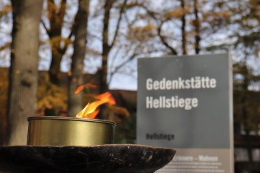 Infostele mit Fackel am Eingang der Gedenkstätte Hellstiege