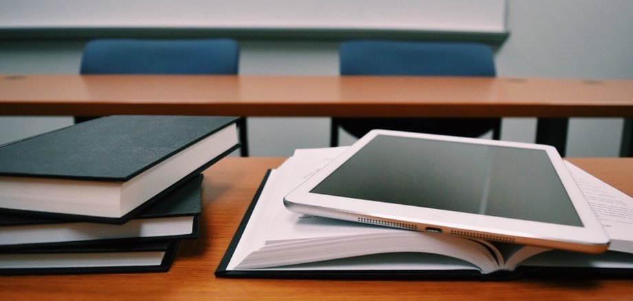 Bücher und Tablets auf den Tischen eines Klassenraums