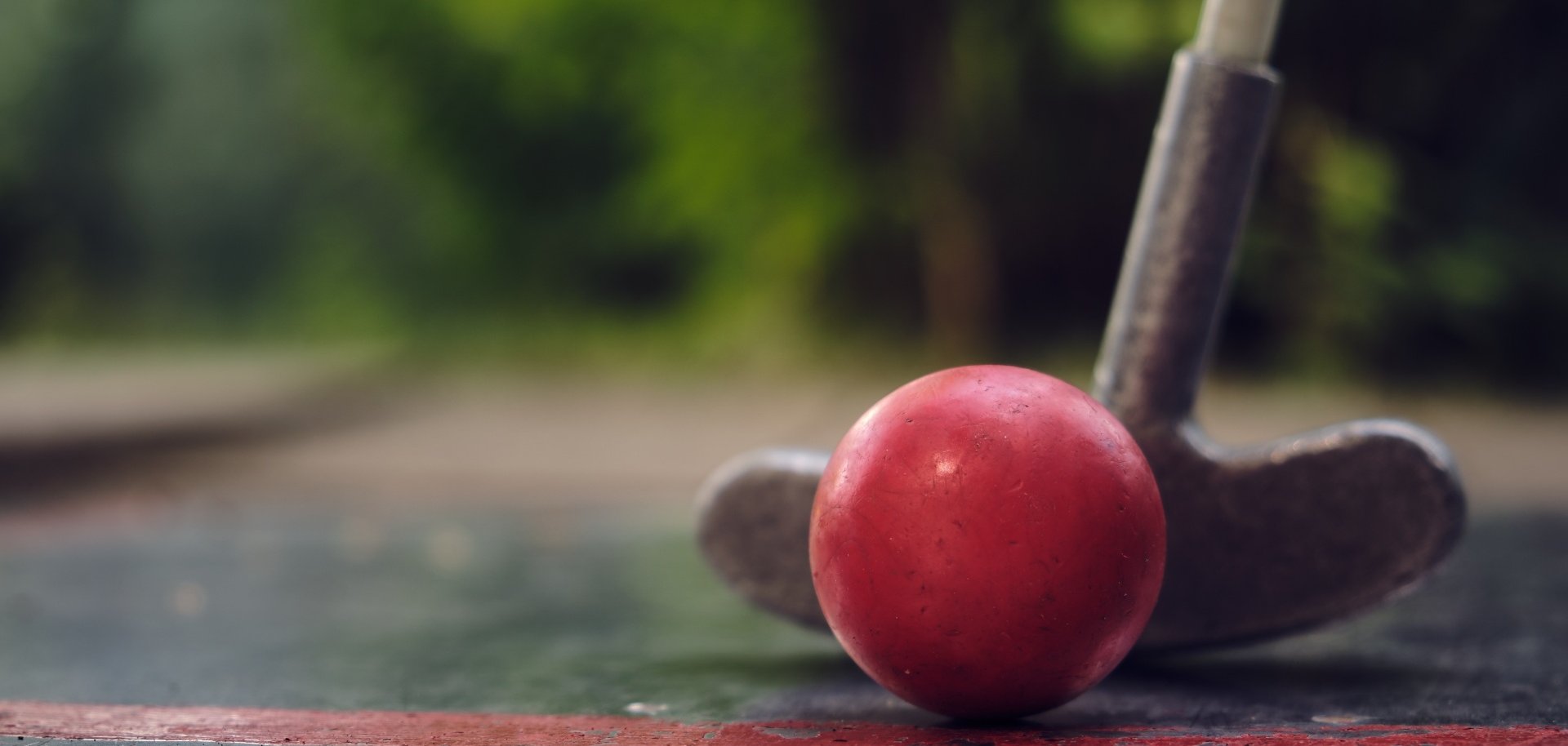 Sie sehen: eine rote Minigolfkugel mit Schläger