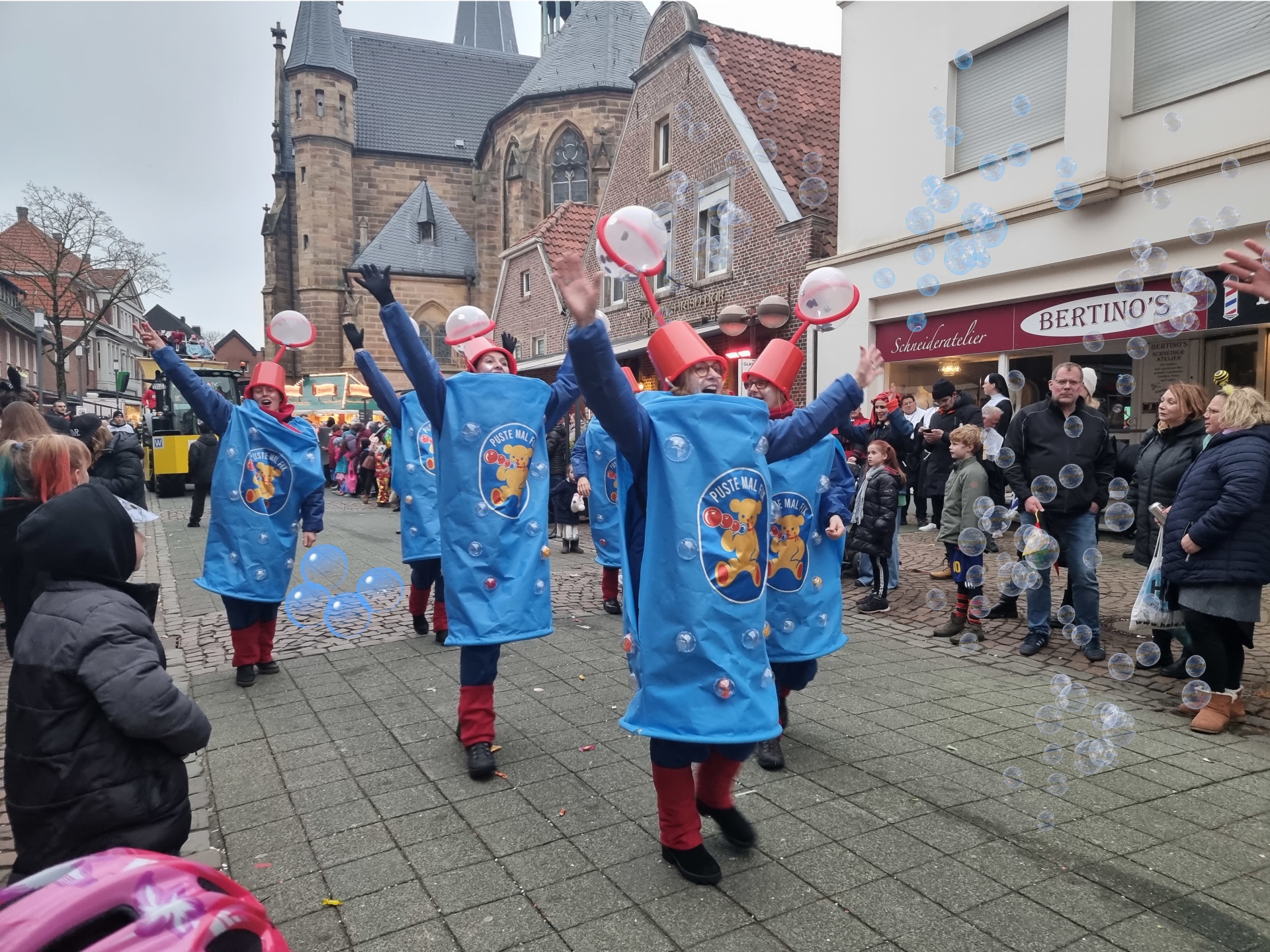 Sie sehen: eine kostümierte Fußgruppe zieht beim Rosenmontagsumzug durch die Fußgängerzone