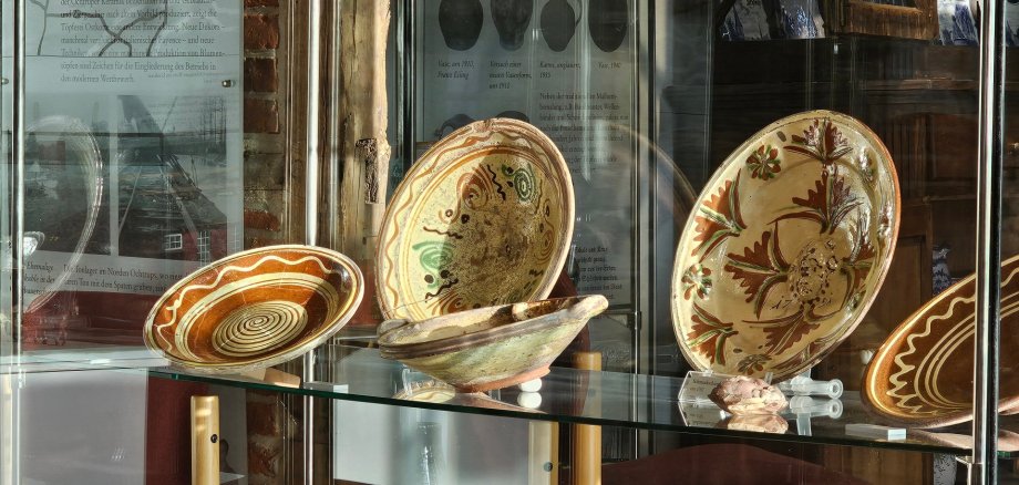 Sie sehen: Alte Töpferwaren in der Vitrine des Töpfereimuseums