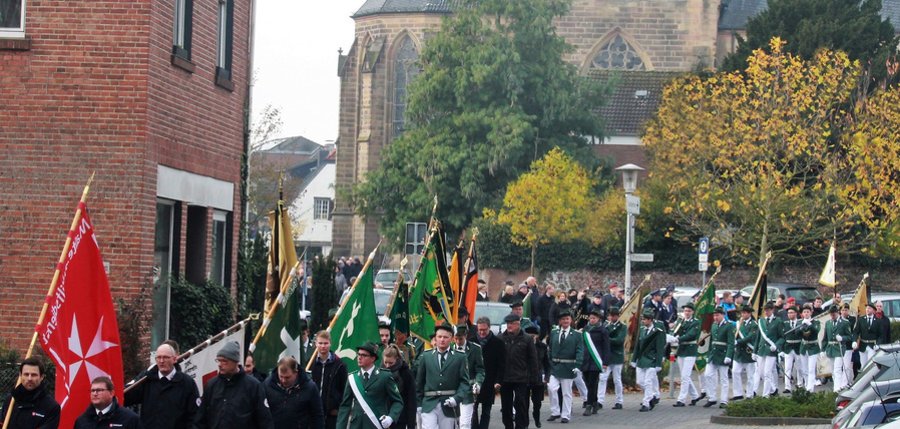 Menschenzug mit Fahnen am Volkstrauertag