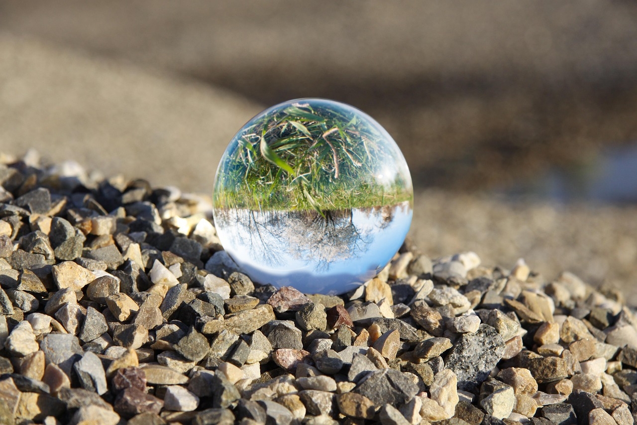 Sie sehen: Eine Glaskugel auf einem Schotterplatz