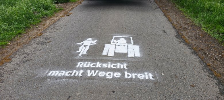 Sie sehen: einen Weg mit der Markierung "Rücksicht macht Wege breit"