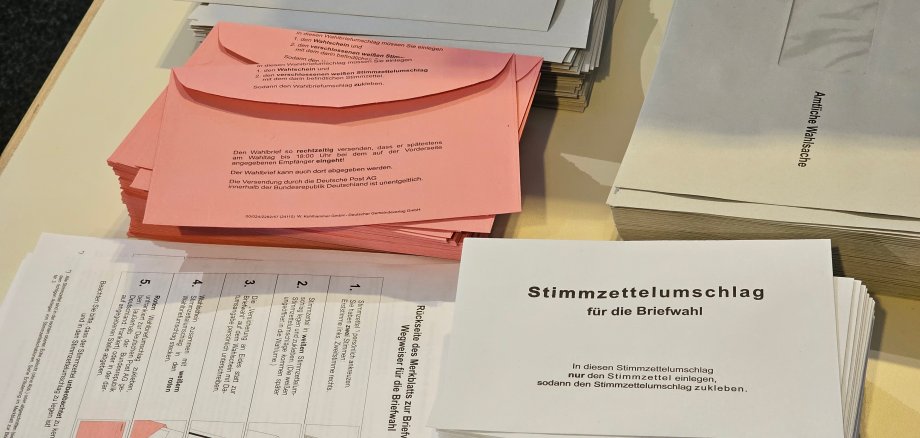 Sie sehen: Briefwahlunterlagen auf einem Tisch
