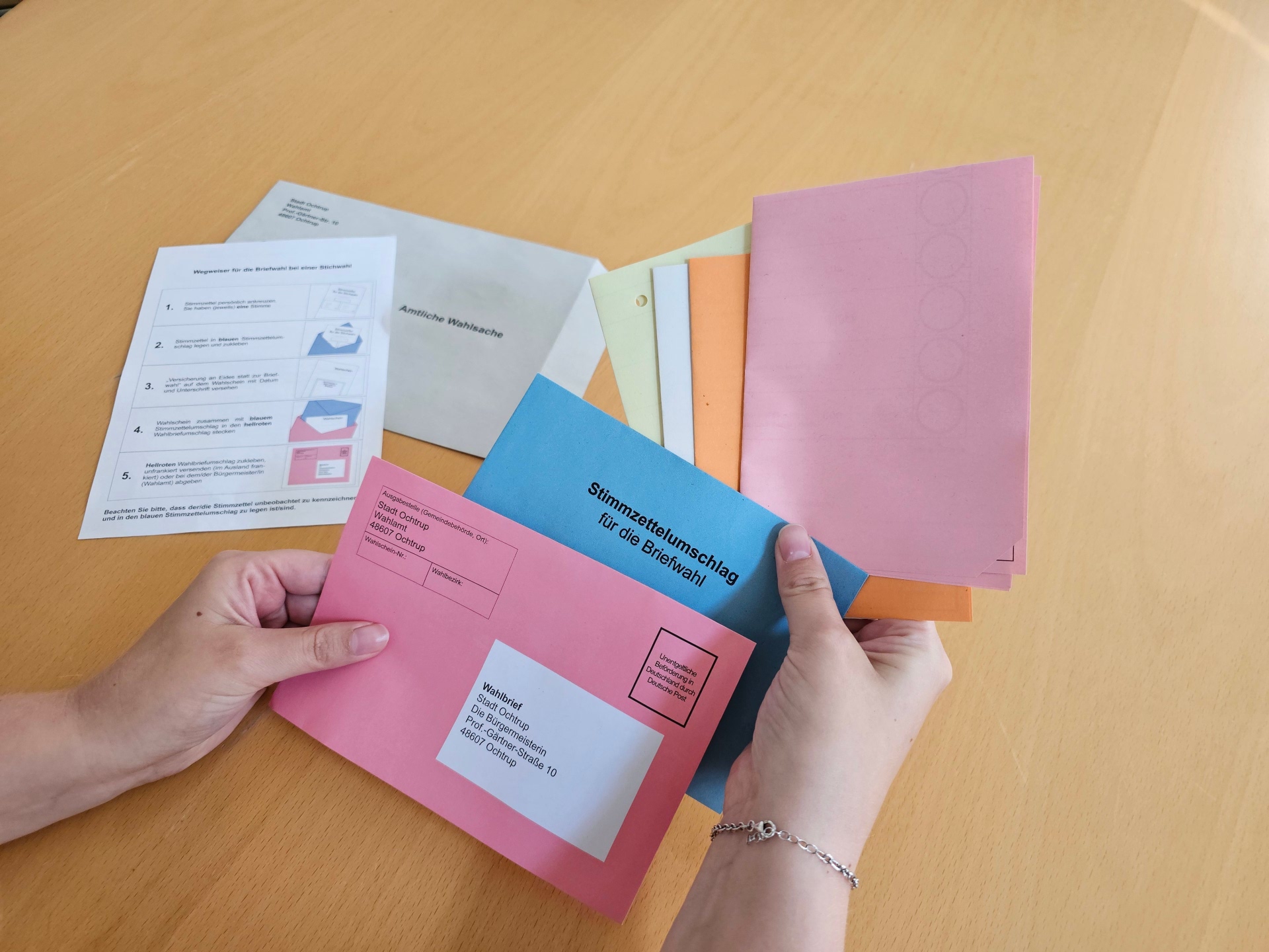 Sie sehen: Stimmzettel werden in den Briefwahl-Umschlag für die Kommunalwahl 2025 geschoben