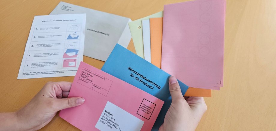 Sie sehen: Stimmzettel werden in den Briefwahl-Umschlag für die Kommunalwahl 2025 geschoben