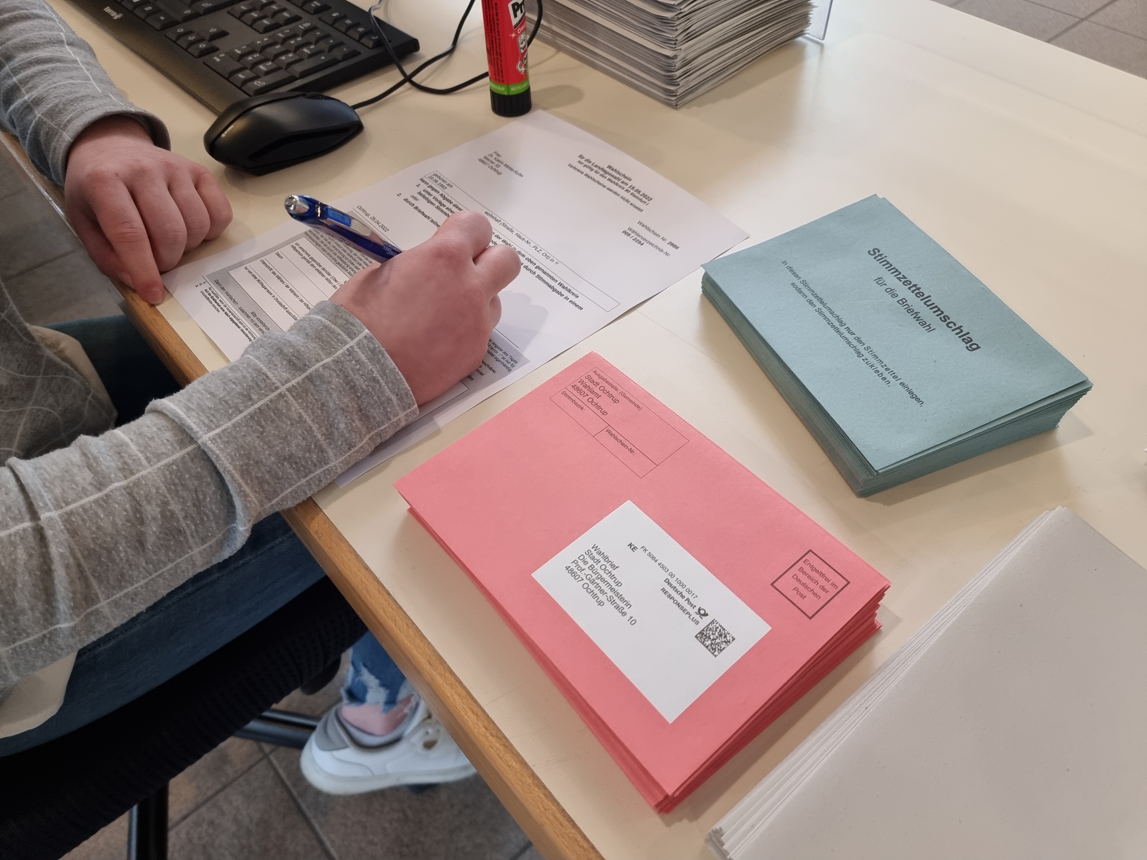Sie sehen: einen Schreibtisch mit Briefwahlumschlägen