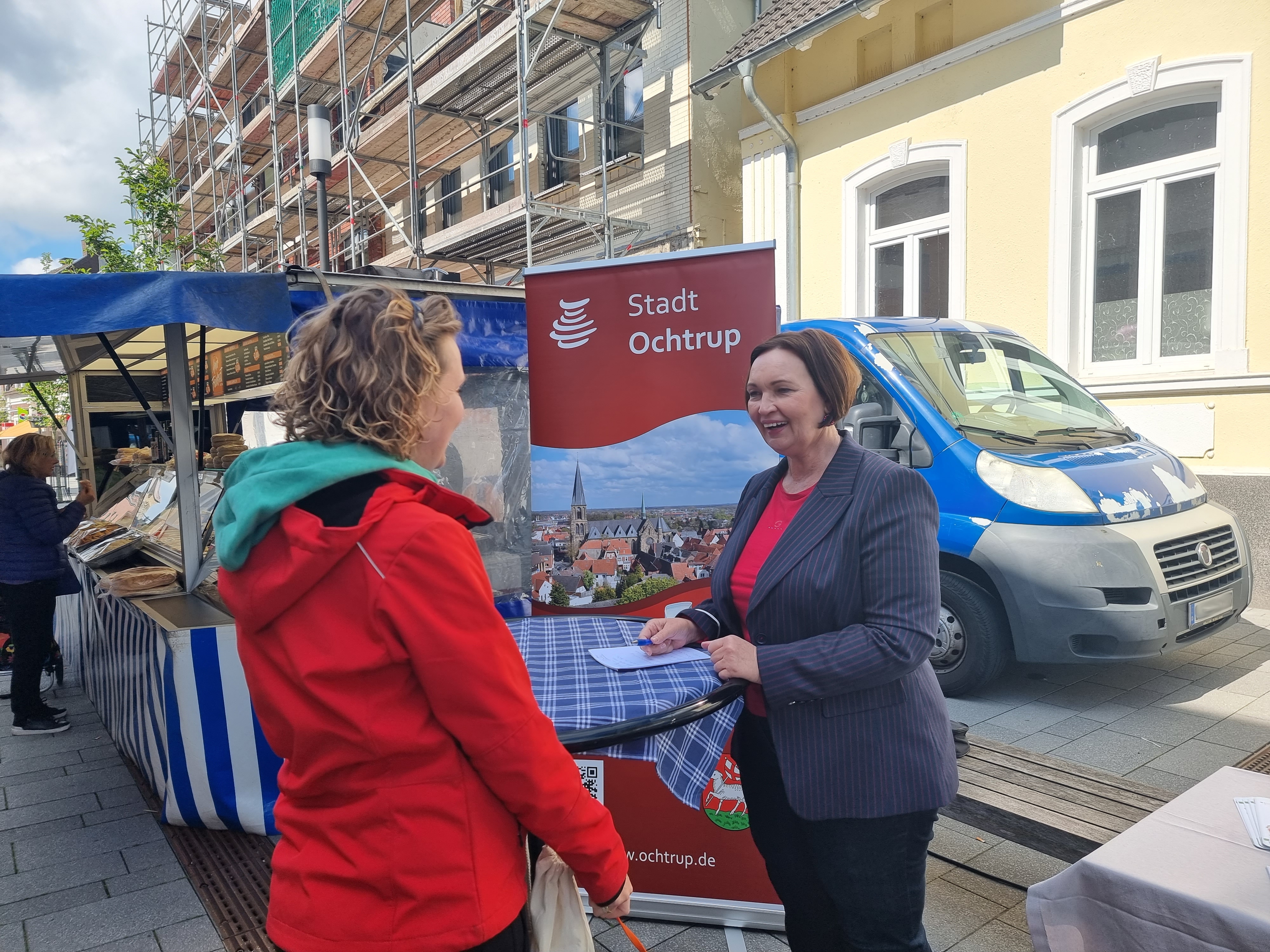 Sie sehen: Zwei Personen im Gespräch an einem Stehtisch: Bürgermeisterin Christa Lenderich auf der Wochenmarktsprechstunde