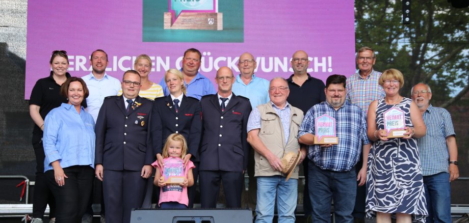 Sie sehen: Bürgermeisterin Christa Lenderich ( vorne links) mi den Vertretern der OST und den Gewinnern des Heimatpreises auf der Bühne.