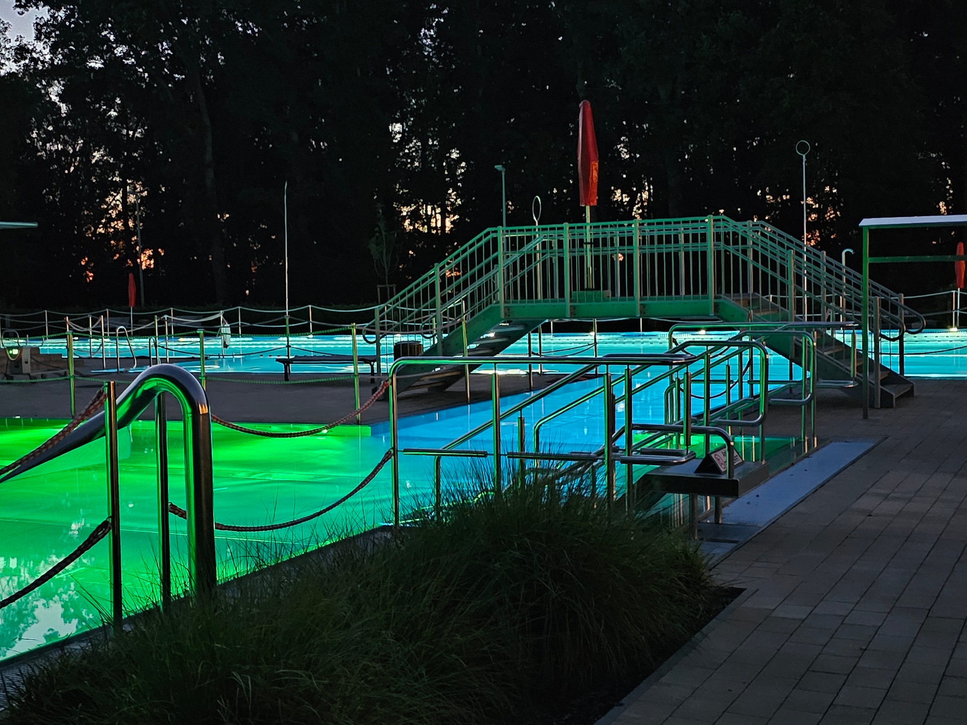 Sie sehen: ein beleuchtetes Schwimmbecken mit Brücke
