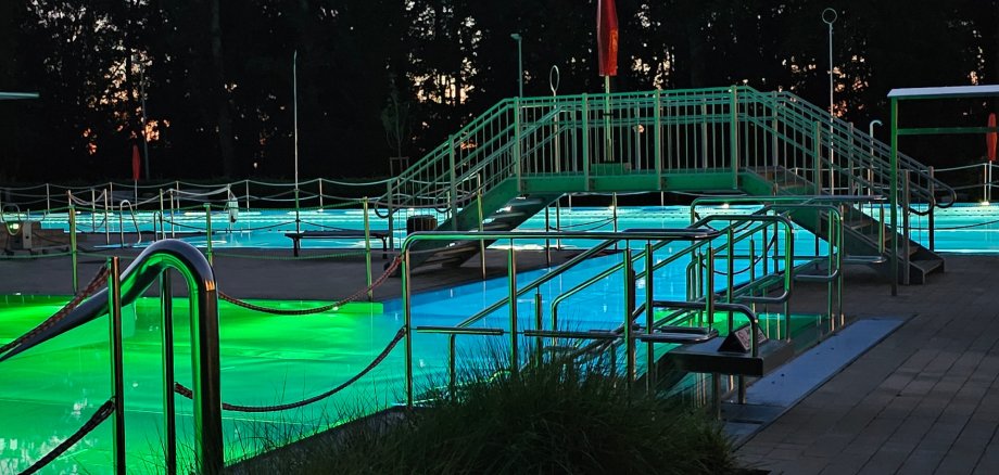 Sie sehen: ein beleuchtetes Schwimmbecken mit Brücke