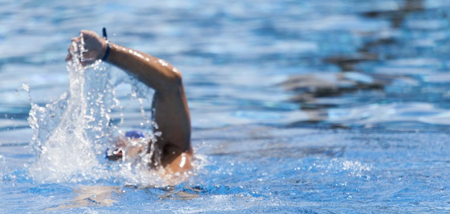 Schwimmer in der Schwimmbahn im Freibad